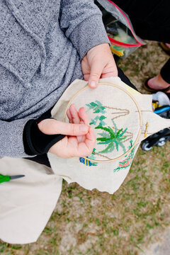 Woman's hands cross-stitching