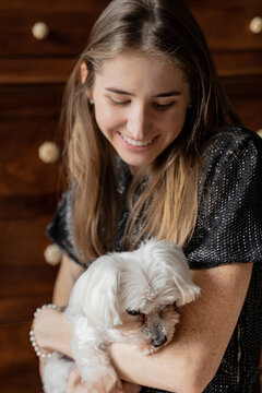 Smiling Woman Holding Cute White Dog 