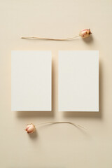 Wedding invitations cards templates with dried flowers on beige background. Flat lay, top view, copy space.