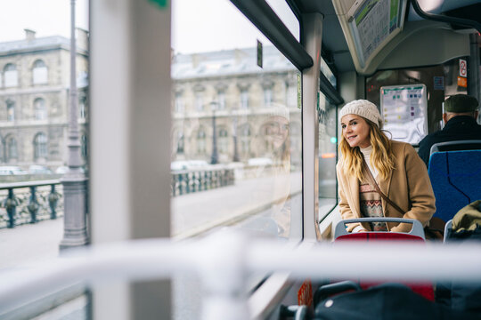 Content woman riding bus during trip