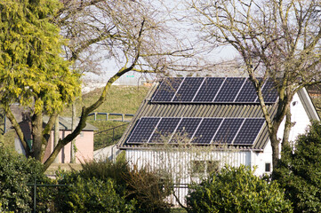 Small white shed with a brown roof with solar panels in the Netherlands