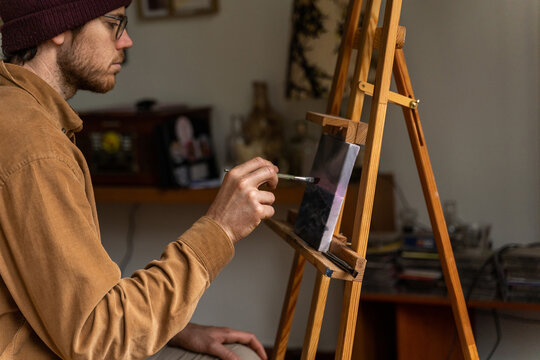Serene man painting a canvas at home