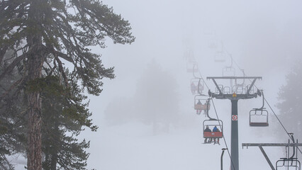 Ski lift in the fog, winter sports in bad weather. Mount Olympus ski resort, Cyprus