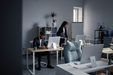 Female colleague coming in and sitting to her workplace
