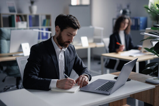 Busy male worker trying concentrate on writing notes