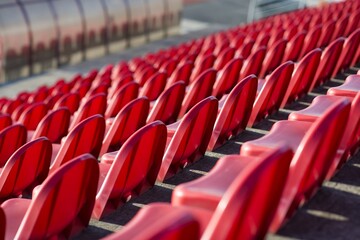 red benches of football - athletic stadium, sun set, place for spectators and athletes