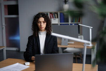 Female lawyer browsing laptop at workplace