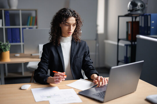Busy female broker using laptop for working in office