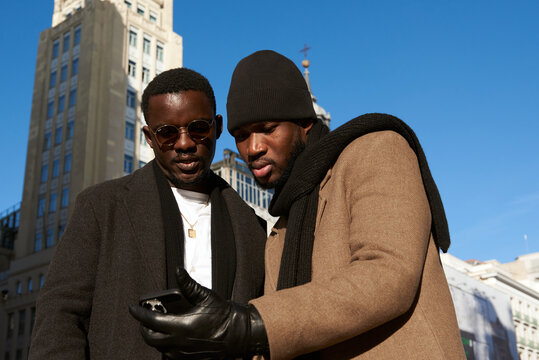 Two Men friends checking the phone at the city