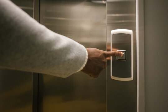 Crop person pressing lift button