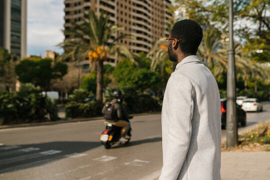 Trendy African American man crossing road