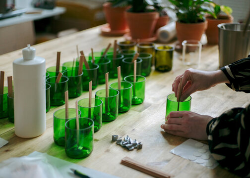 Manufacture of natural wax candles with wooden wicks.