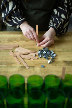 Manufacture of natural wax candles with wooden wicks.