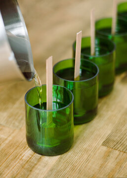Manufacture of natural wax candles with wooden wicks.