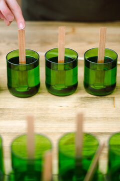 Manufacture of natural wax candles with wooden wicks.