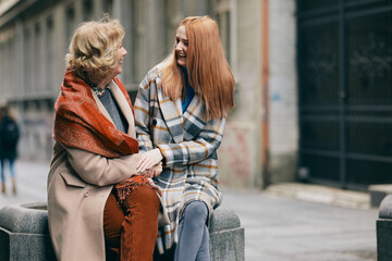 Grandmother and granddaughter laughing and bonding outside.