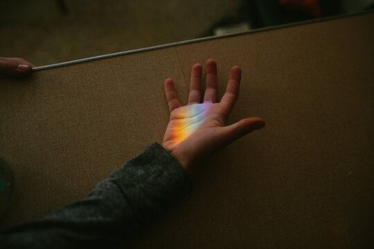 hand in rainbow light beam