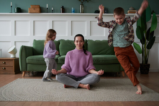 Children run around the mother in the lotus position