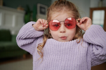 Cute young girl with sunglasses making a surprised face.
