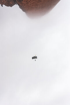 Anonimous base jumpers flying over mountain range