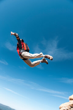 Extreme sportsman BASE jumping from mountain summit