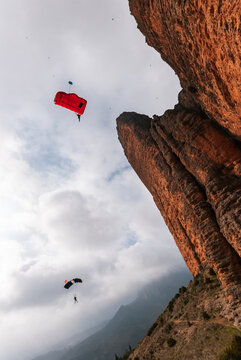 Anonimous base jumpers flying over mountain range