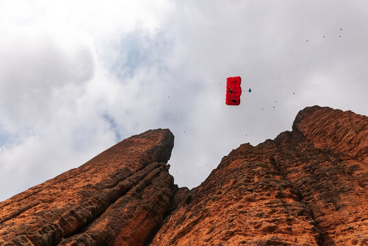 Anonimous base jumpers flying over mountain range