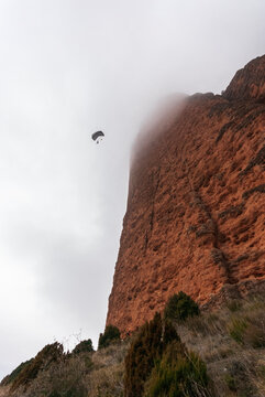 Anonimous base jumpers flying over mountain range