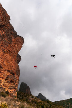 Anonimous base jumpers flying over mountain range