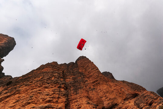 Anonimous base jumpers flying over mountain range