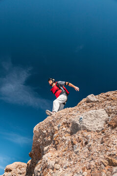 BASE jumper wearing parachute extiting from a cliff