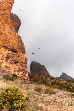 Anonimous base jumpers flying over mountain range