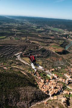 Thrill-seeker BASE jumping taking off from summit