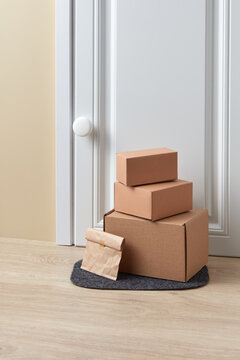 Cardboard boxes standing on door mat near entrance