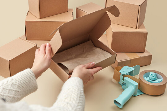 Close up of woman preparing boxes for online delivery