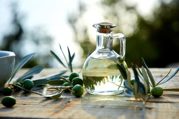 olive oil and green olive on the wooden background - obrazy, fototapety, plakaty