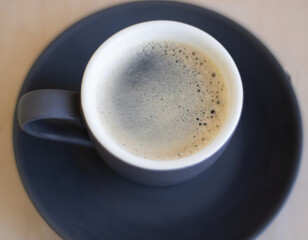 espresso in a gray cup with foam on a light background