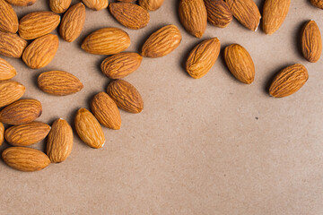 Close up almonds on dark paper table. Organic health protein vegetarian food. Background copy space