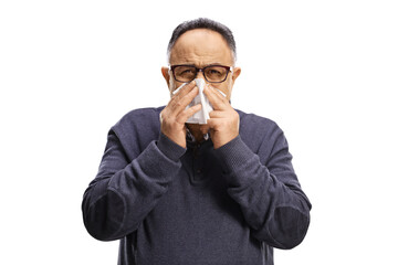 Mature man blowing nose with a paper tissue