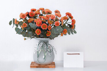 beautiful bouquet of fresh chrysanthemums in vase on white table, happy mothers day background, copy space