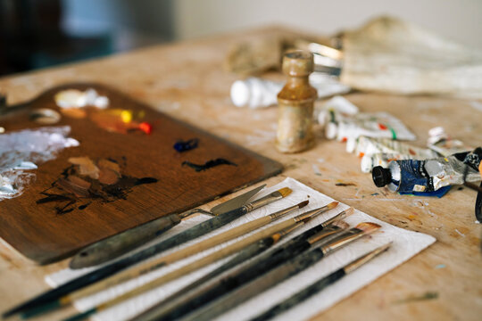 Artists paint brushes, paint pallets, and paint tubes