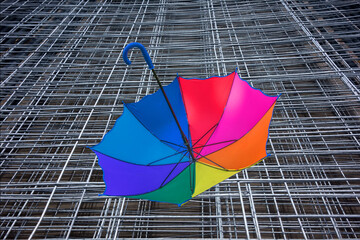 Multicolored rainbow umbrella dried on metal racks