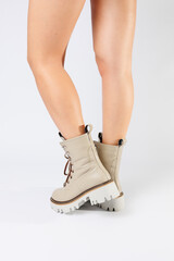 Women's white spring boots made of genuine leather are worn on a woman's leg. New collection of women's boots 2022