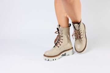 Women's white spring boots made of genuine leather are worn on a woman's leg. New collection of women's boots 2022