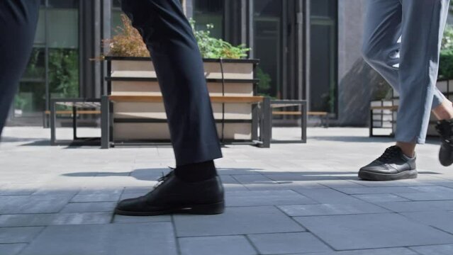 Closeup corporate people legs walking downtown on sunny day. City lifestyle.