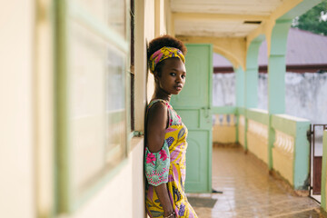 Black woman in colorful authentic outfit on balcony