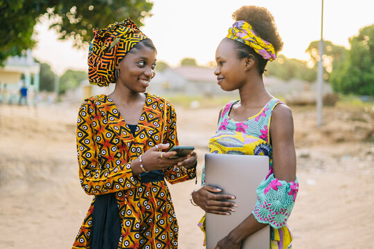 Two girlfriends using smartphone on street