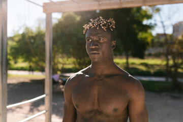 Shirtless black athlete standing on a sports field