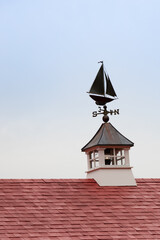 Sailboat-shaped weather vane with blue sky background