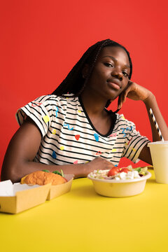 Woman choosing between healthy and fast food